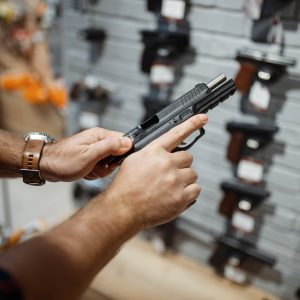 Man choosing new handgun in gun shop